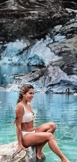 Woman sitting on rock by serene lake.