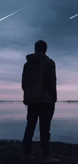 Silhouetted figure at sunset on a peaceful lake reflecting the evening sky.