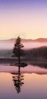 Serene sunset over a lake with a lone tree and misty mountains.