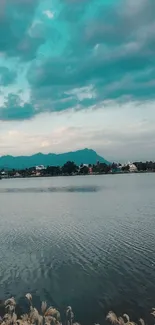 Tranquil lake and turquoise sky with distant mountains.