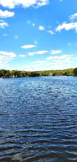 Beautiful lake with blue sky and lush green trees.