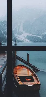 Serene view of a wooden boat at a misty lake through a windowpane.