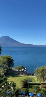 Serene lakeside view with mountain and blue sky.