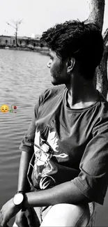 Monochrome portrait of a young man by a lake.