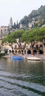 Lakeside village view with trees, mountains, and boats.