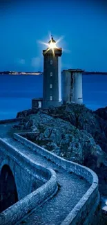 Tranquil lighthouse at night by the ocean.