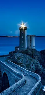Serene lighthouse on rocky coast with a deep blue sea under night sky.