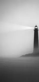 Lighthouse piercing through fog on a calm sea.