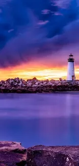 Lighthouse at sunset with vibrant sky over ocean.