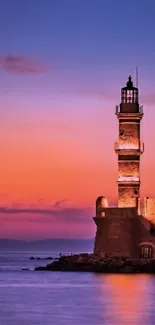 A serene sunset with lighthouse against a vibrant orange and purple sky landscape.