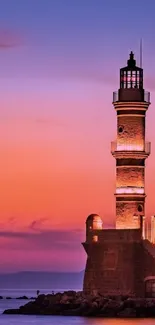 Lighthouse silhouette at sunset with colorful sky and calm ocean.