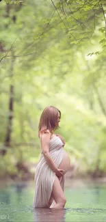 Pregnant woman standing in tranquil forest stream surrounded by lush green trees.