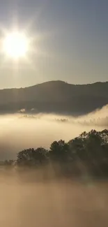 Misty mountain sunrise with golden light and hazy mist.