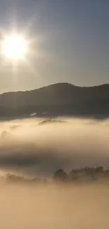 Misty sunrise over mountains with soft light and fog.