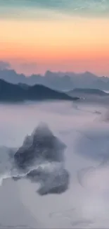 Misty mountain landscape during sunrise with serene clouds.