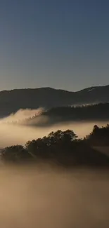 Misty mountain landscape wallpaper with fog and hills at sunrise.