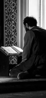 A person reading in a monochrome peaceful room.