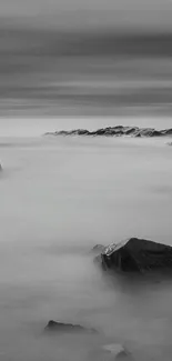 Monochrome wallpaper with sea rocks and a calming ocean view.