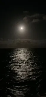 Moonlight casts a serene glow on a dark ocean at night.