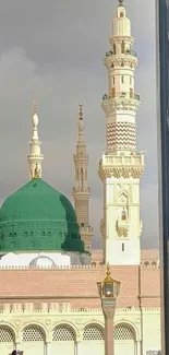 Green dome mosque with towering minarets and intricate architecture.