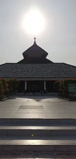 Sunlit mosque entrance with clear sky.