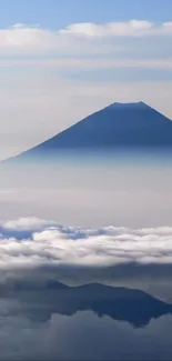 Majestic mountain peak above clouds on a blue sky.