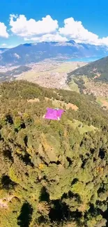 Aerial view of lush green mountains and valleys under a clear blue sky.