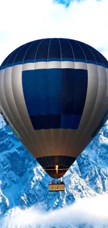 Hot air balloon over snowy mountains.