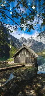 Scenic view of lake with a quaint cabin surrounded by mountains and lush greenery.