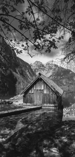 Black and white wallpaper of a lakeside mountain cabin in serene nature.