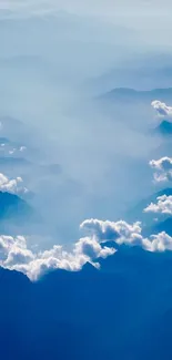 Serene mountain landscape with clouds and blue sky, perfect for phone wallpaper.