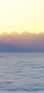 Tranquil mountain sunrise with golden sky and misty clouds.