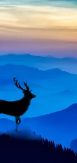 Blue mountain landscape with deer silhouette at sunset.