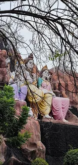 Serene mountain garden with sculptures and trees.