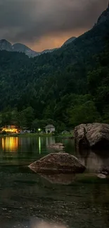 Calm mountain lake with forest and rocks at dusk.