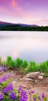 Mountain lake at sunset with purple sky and lush green landscape.