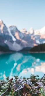 Serene mountain lake with reflection of snow-capped peaks under a clear blue sky.