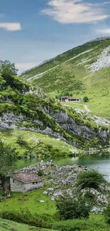 Tranquil mountain lake with green hills and a rustic cabin.