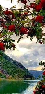 A serene mountain lake with red flowers and lush greenery.