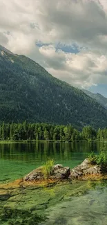 Tranquil mountain lake with lush greenery and clear sky.