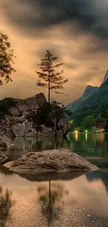 Serene mountain lake with rocky shore at dusk.