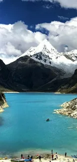 Turquoise mountain lake with snow-capped peaks and blue sky.