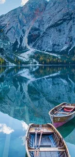 Mountain lake with wooden boats and reflections.