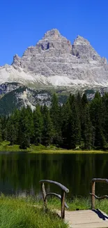 Tranquil mountain and lake with blue sky and green forest.