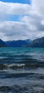 Serene mountain lake wallpaper with blue sky and waves.