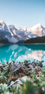 Serene view of a mountain lake with snow-capped peaks and greenery.