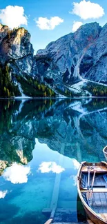 Mountain lake with boats and sky reflection.