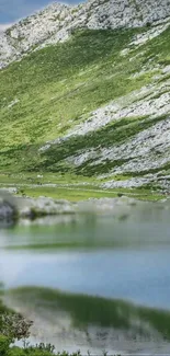 Serene mountain lake with green hills reflection.