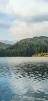 Serene mountain lake with forest and blue sky.