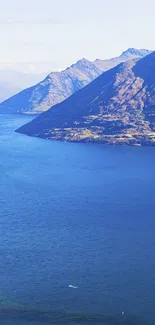 Stunning blue lake beside majestic mountains under a clear sky.